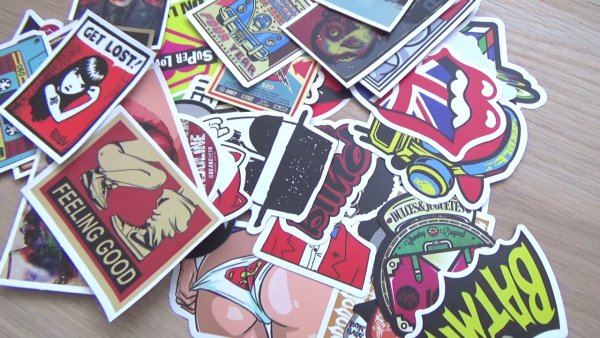 Клеит наклейку на телефон