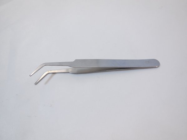 Рука с пинцетом для наращивания ресниц