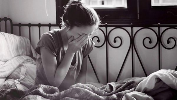 Женщина плачет на кровати