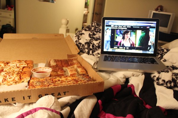 Ноутбук с фильмом на кровати