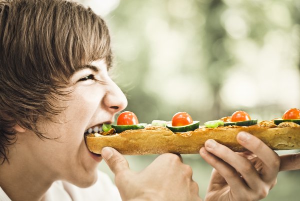 Парень ест бутерброд