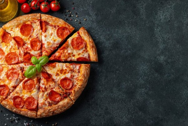 Пицца пепперони на черном фоне