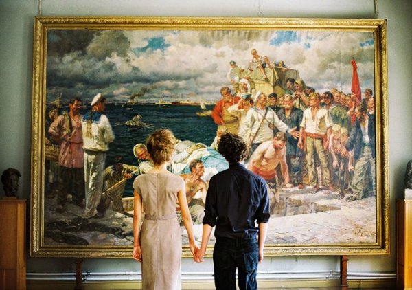 Люди смотрят на картину в музее