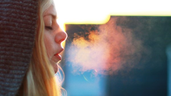 Девушка выдыхает воздух