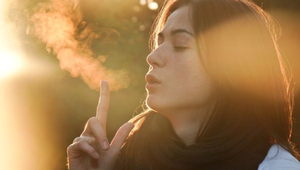 Девушка выдыхает воздух