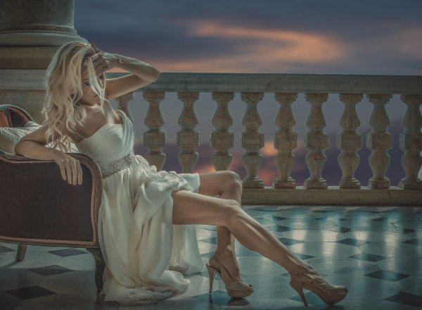 Девушка в платье на коленях сидит