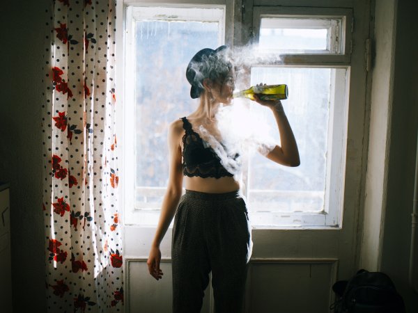 Девушка курит на кухне