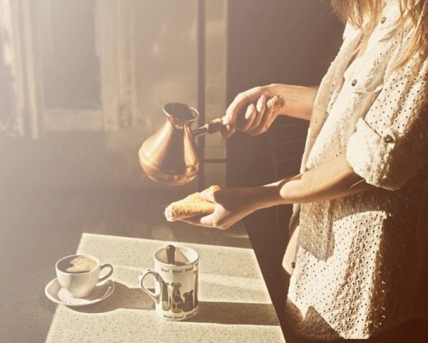 Девушка с чашкой кофе у окна