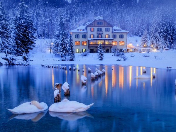 Дом у озера в горах зимой