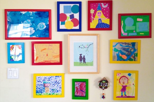 Детские рисунки в рамках на стене