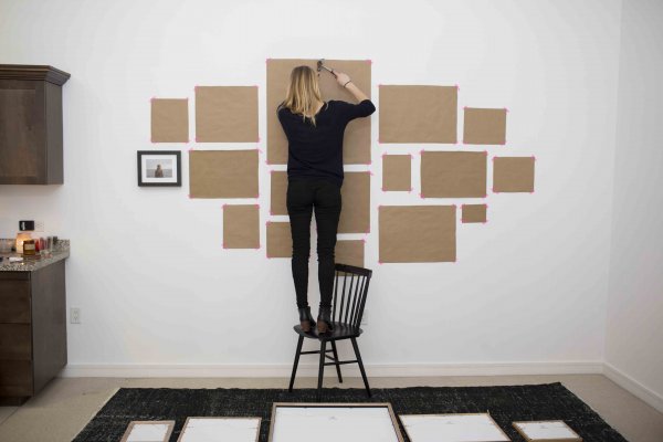 Человек вешает картину на стену