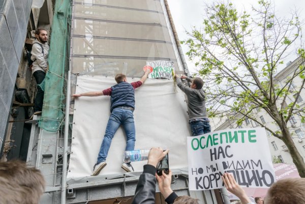 Человек вешает плакат