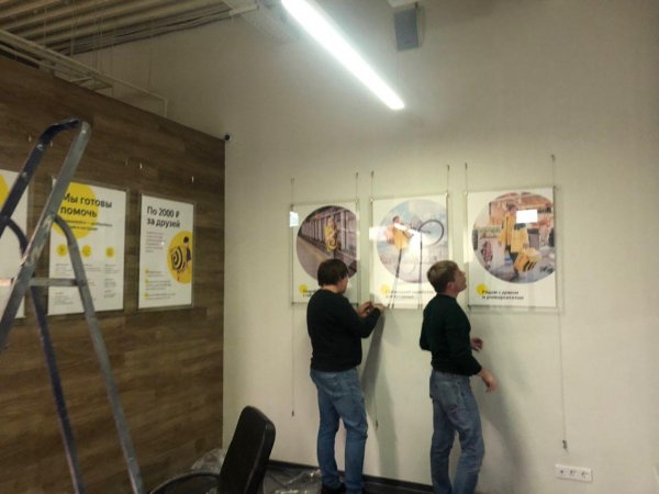 Вешают плакат на улице