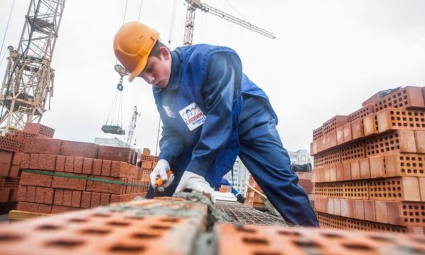 Строитель с каской в руке