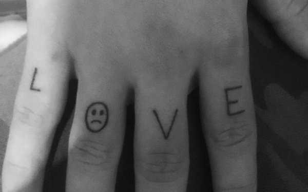 Тату смайлик на пальце руки