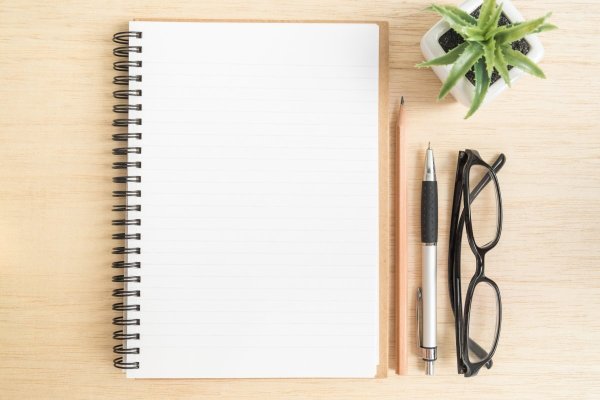Открытый блокнот с ручкой на столе
