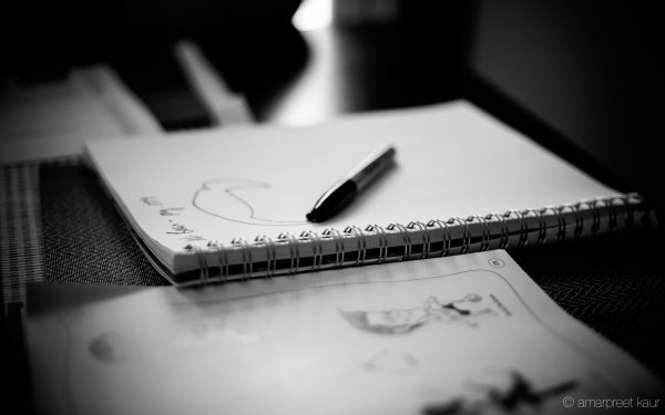 Блокнот и ручка на черном фоне