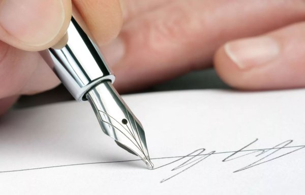 Рука подписывает документ