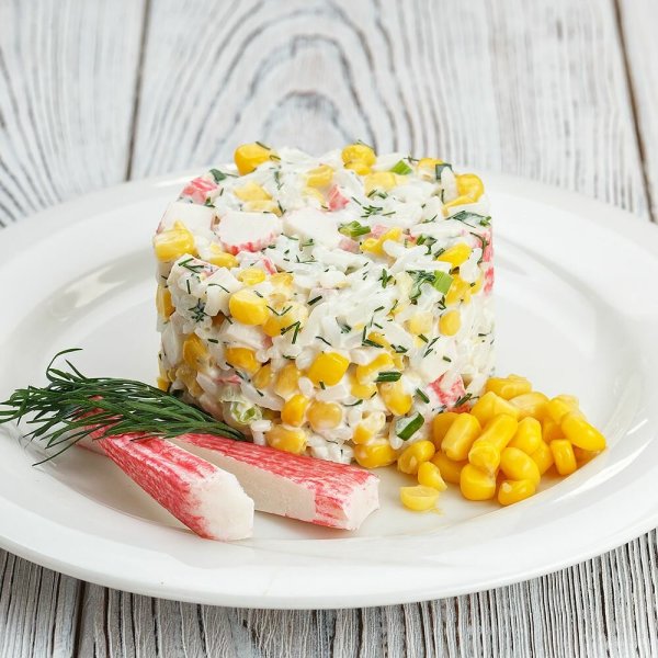 Крабовый салат на белой тарелке