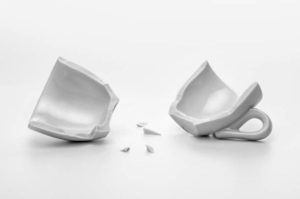 Разбитая чашка на белом фоне