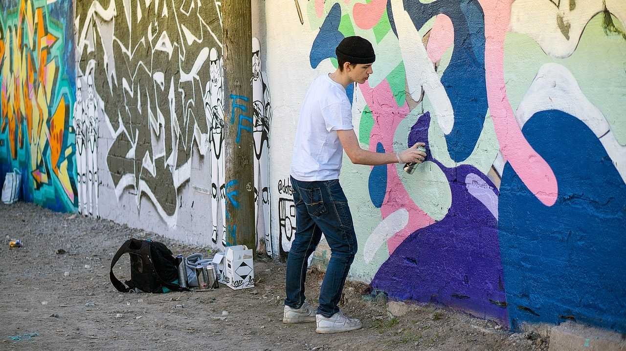 Подросток рисует на стене