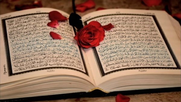 Открытый Коран и цветы