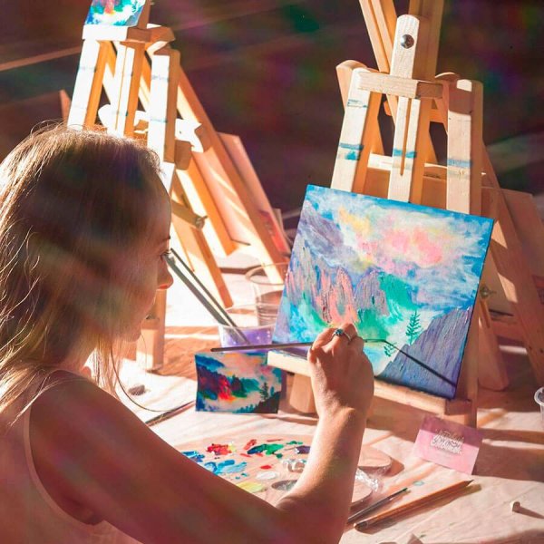 Ребенок-художник с мольбертом и кисточками