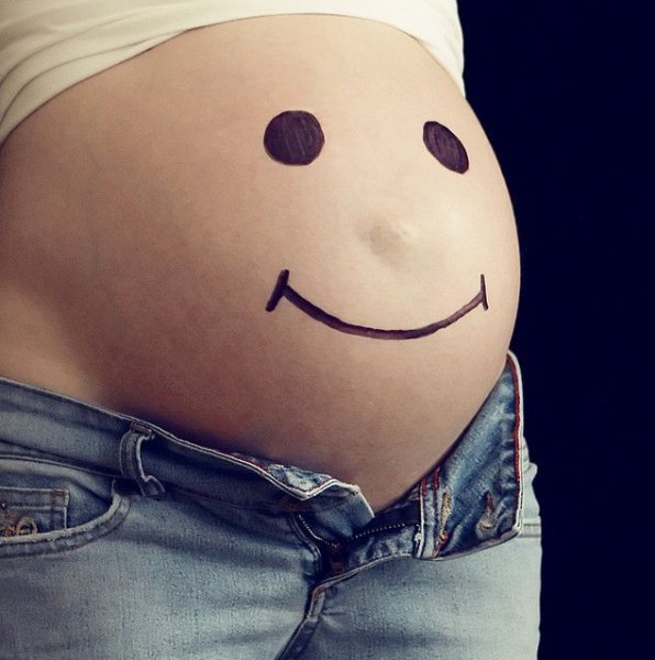 Смайлик на животе беременной
